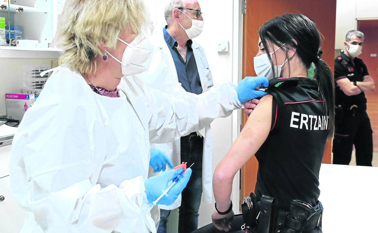 Un equipo sanitario inocula la primera dosis de la fórmula de la Astrazeneca a una agente de la Ertzaintza. 