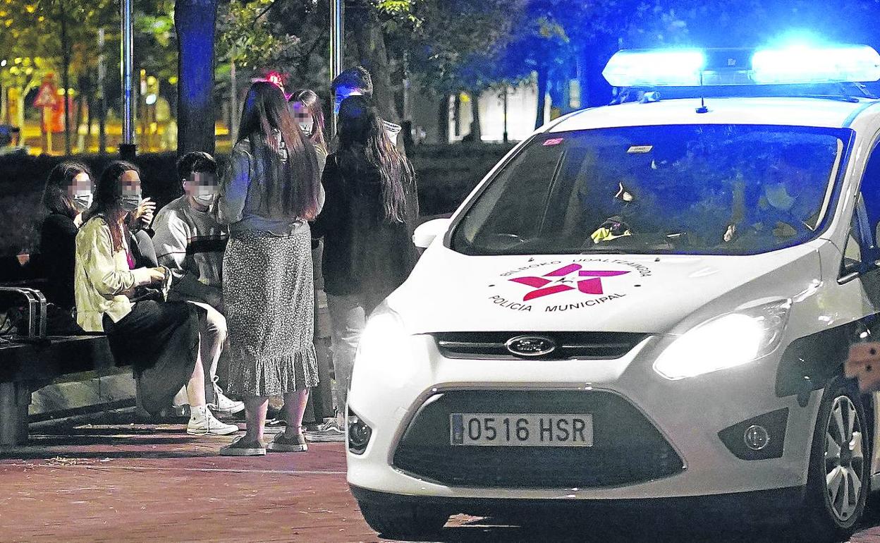Una patrulla de la Policía Municipal de Bilbao pasa junto a un grupo de jóvenes el pasado fin de semana al decaer el estado de alarma. 