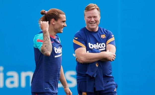 Ronald Koeman sonríe junto a Antoine Griezmann durante el entrenamiento de este sábado. 