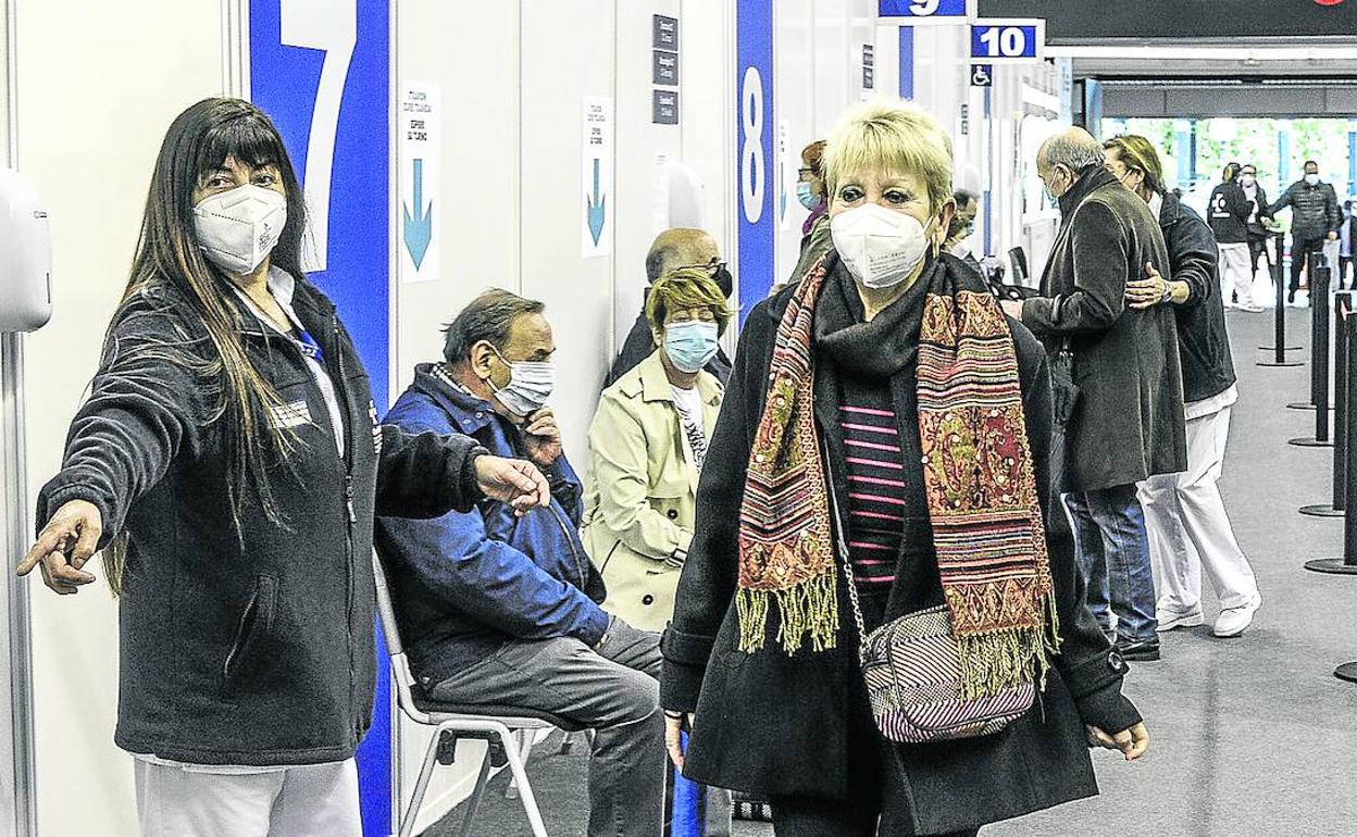 Una sanitaria indica ayer a una mujer el lugar donde debe esperar antes de ser vacunada en uno de los boxes habilitados en La Casilla. 