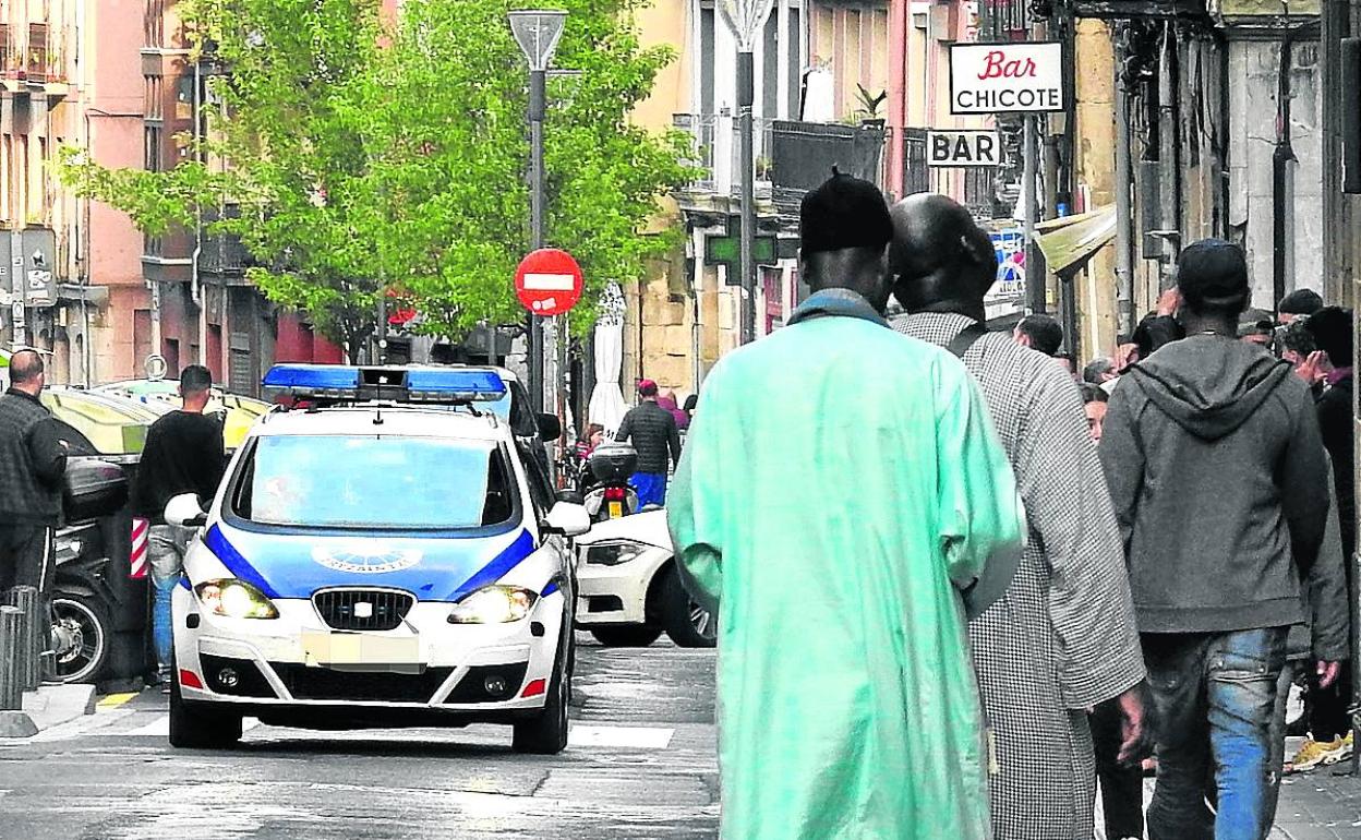 Un coche patrulla de la Ertzaintza atraviesa una calle del multicultural barrio de San Francisco. 