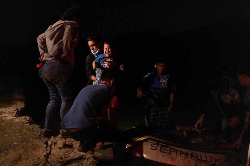 Carlo llora cuando otra inmigrante lo saca de la balsa en la que ha llegado junto a su madre.