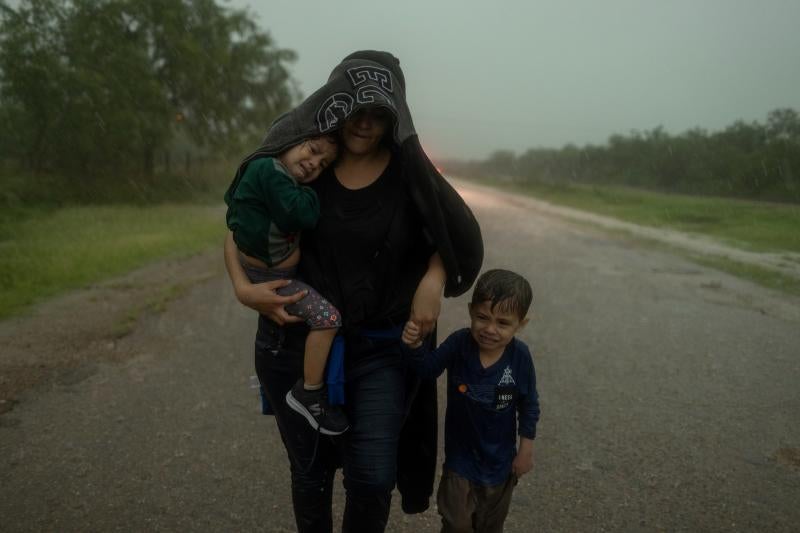 Bajo el aguacero, Claudia busca refugio junto a sus hijos Dylan, de 4 años, y Fernanda, de 2.
