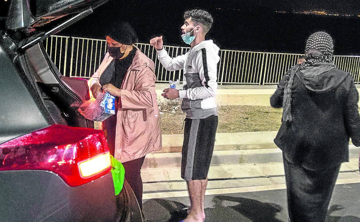 Sabaj reparte ayer comida por las calles de Ceuta junto a su amiga Nayat y el joven Abdlghani.