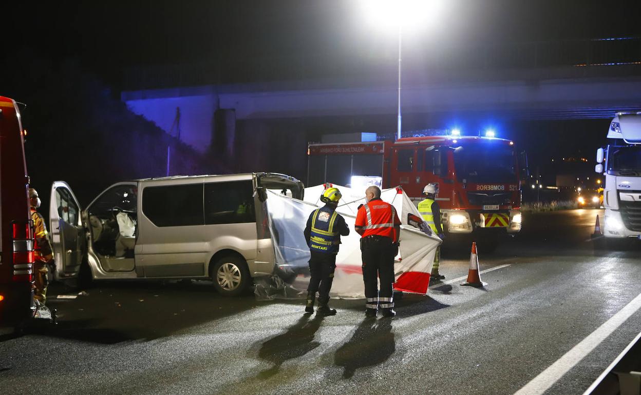 Ertzainas y bomberos junto a la furgoneta siniestrada en la autopista cerca de la localidad alavesa de Armiñón. 