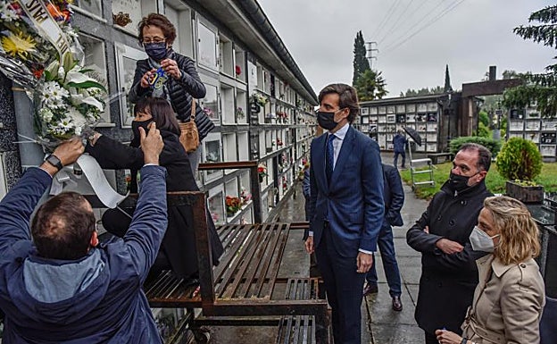 La viuda de Pedrosa, Mari Carmen Hernández, coloca los ramos junto a la lápida de su marido. 