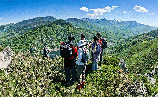 Un grupo de personas hace un alto en el embalse de la Cohílla del Camino del Potro, en el Parque Natural Saja-Besaya. 