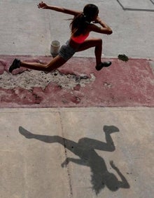 Imagen secundaria 2 - Arriba, el padrastro de Yulimar, con una sudadera con la imagen de la atleta. Abajo, su primer entrenador, Jesús Velásques, delante de un cartel en el que aparece la saltadora. Junto a ello, una joven practicando en una deteriorada pista donde Yulimar nació. 