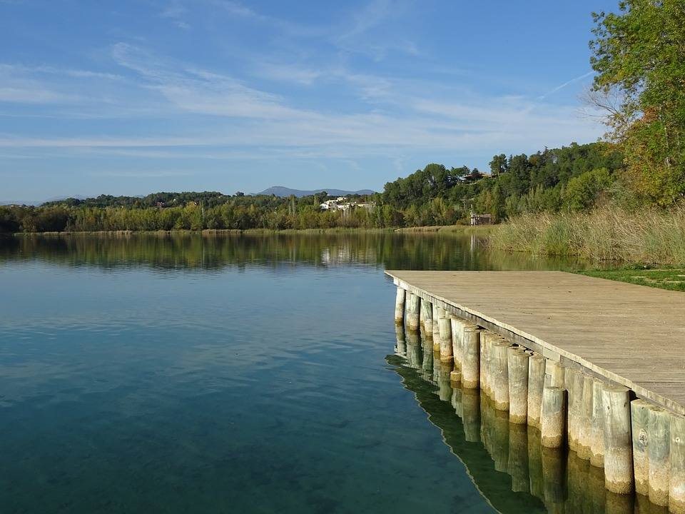 Lago de Banyoles (Girona). En el lago más grande de Cataluña podemos disfrutar de un buen baño gracias a sus tres zonas habilitadas para ello, en las que, además, hay duchas, servicios y socorristas. Cuenta con una superficie de más de un kilómetro cuadrado, una profundidad que alcanza los 60 metros en algunas zonas y se considera el conjunto cárstico más grande de España.