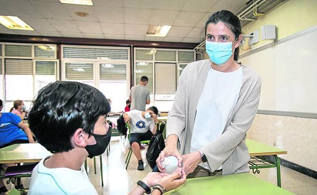 Estíbaliz reparte gel desinfectante en un aula. 