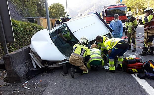Los equipos de emergencias tratan de liberar al conductor herido.