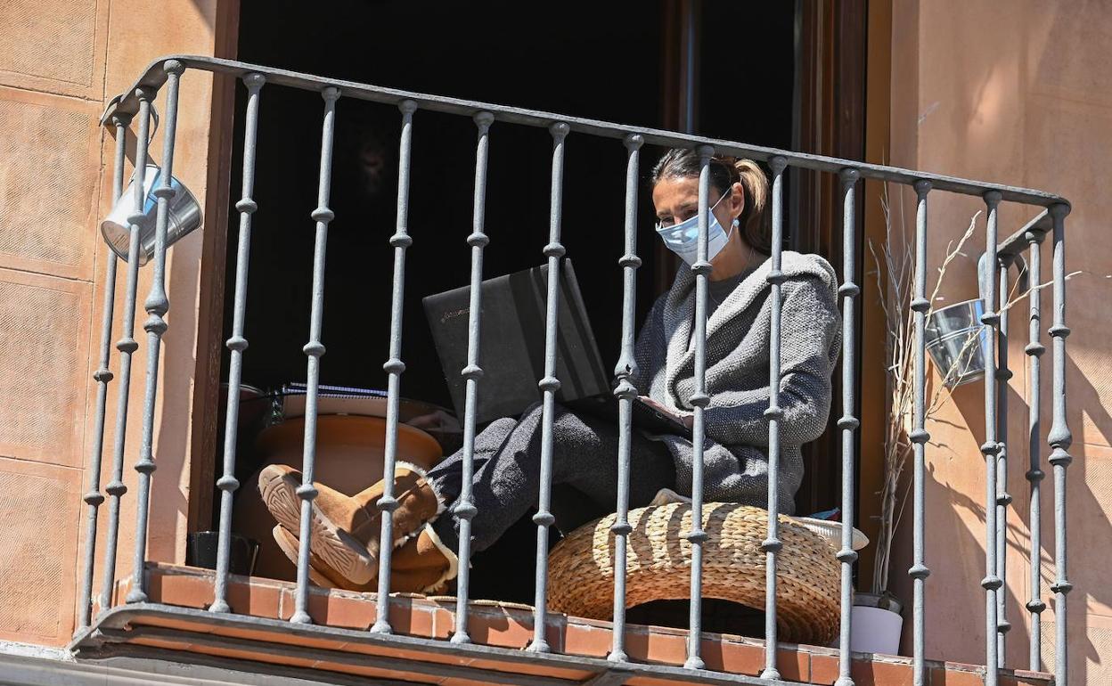 Una mujer sentada en su balcón durante el confinamiento en Alcalá de Henares, Madrid.
