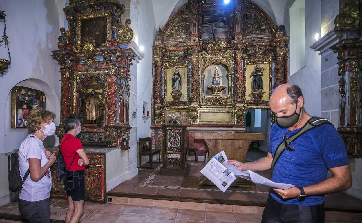 Francisco Navarro consulta la guía durante su visita a la ermita de Jugatxi. 