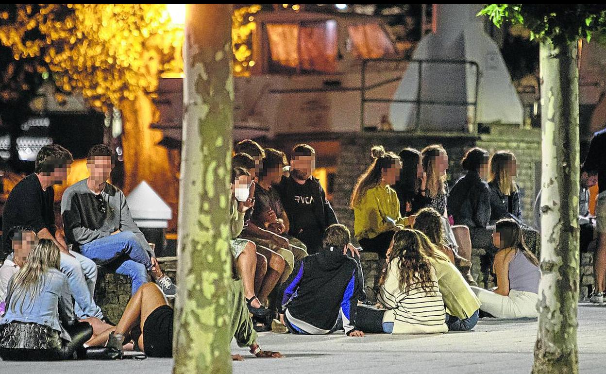 Jóvenes bebiendo en la calle en la medianoche en el puerto de Plentzia.