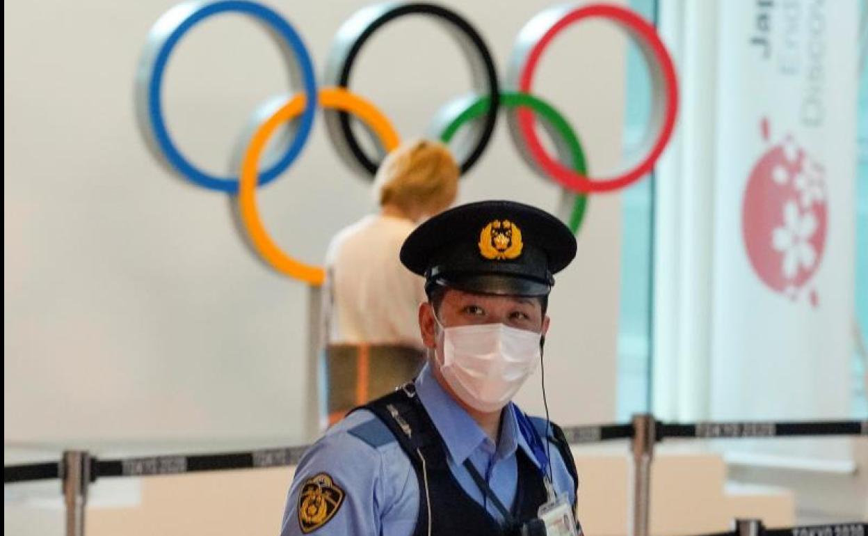 Un policía japonés en el aeropuerto de Tokio, ante los anillos olímpicos.