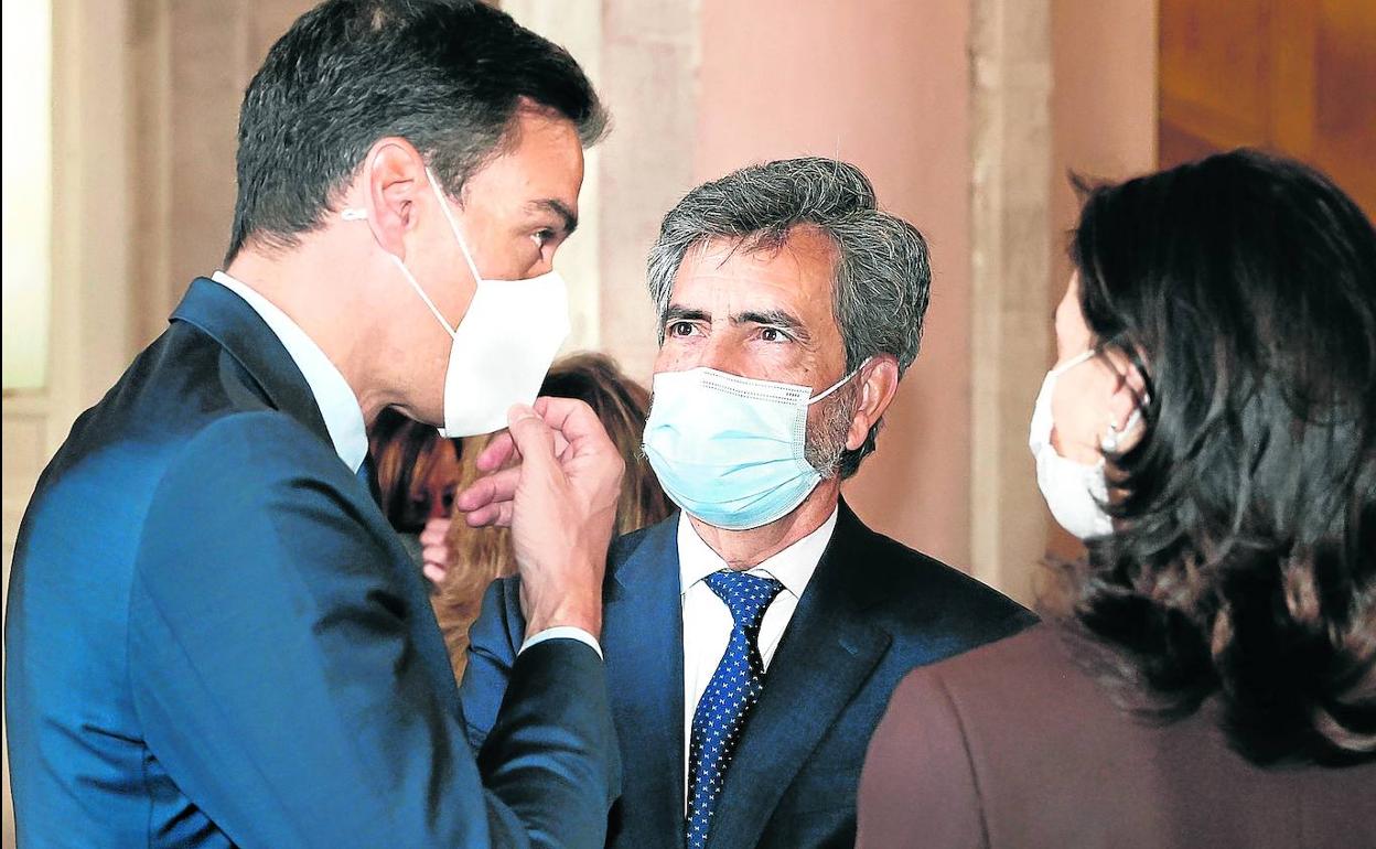 Pedro Sánchez charla con Carlos Lesmes, presidente del CGPJ y del Supremo, en el reciente homenaje a las víctimas del covid.
