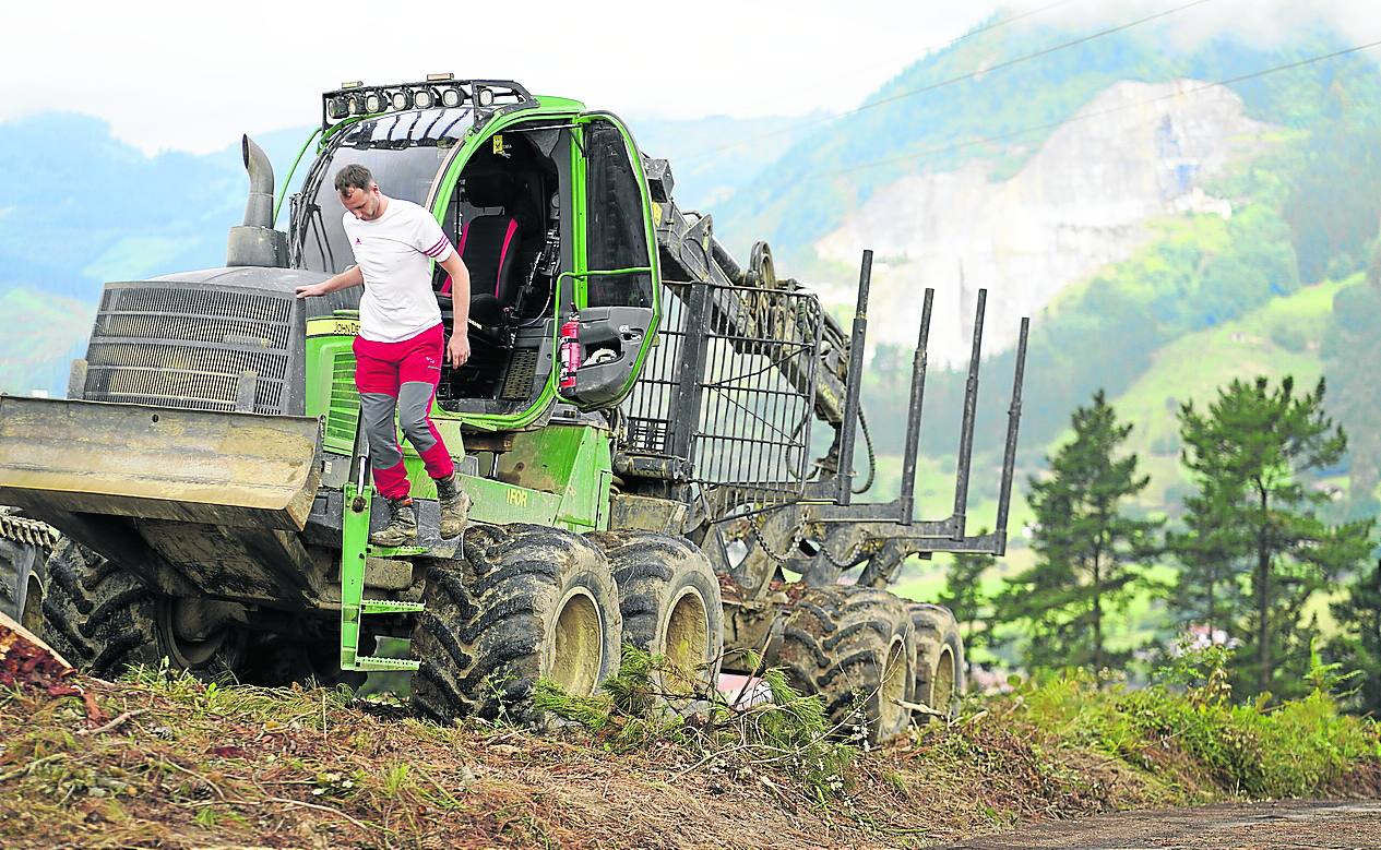 Jon Curac se baja de una máquina transportadora de troncos en un monte de Markina. 