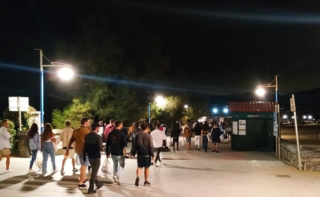 Las cuadrillas de amigos encaran la recta del paseo de la playa. Al final del todo encontrarán el bafle. 