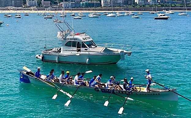 El yate que recorre la costa guipuzcana se cruza con una trainera en La Concha.