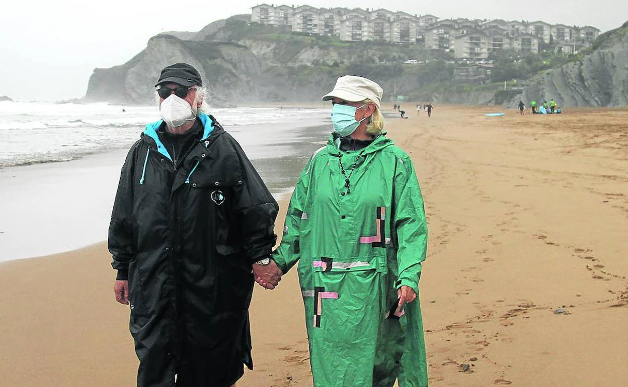 Una pareja pasea ayer por la playa de Sopela, en una nueva jornada marcada por las lluvias. 