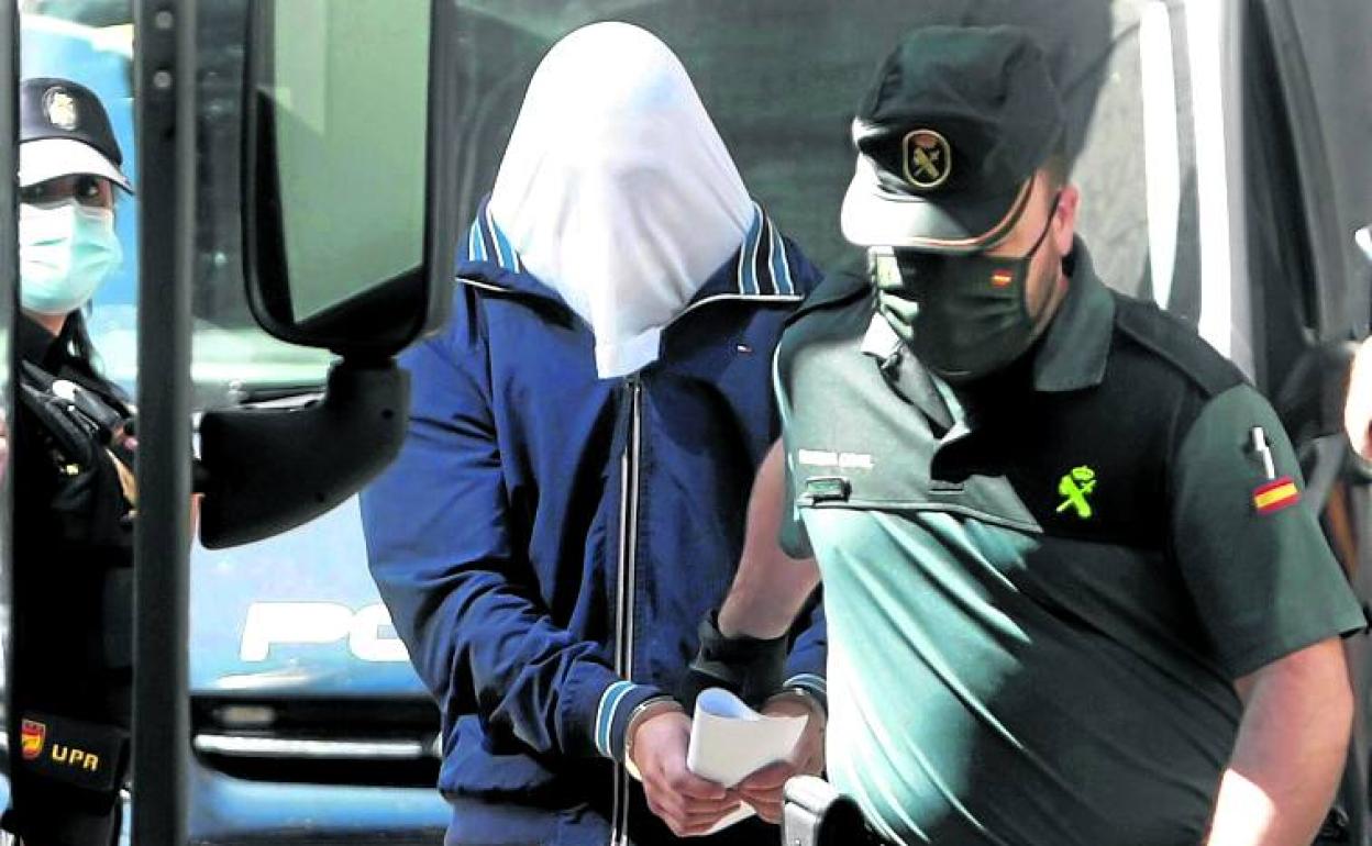 Uno de los detenidos es conducido a declarar ante el juez. 