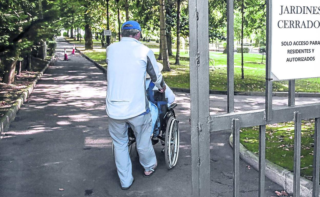 Un familiar acompaña a un dependiente durante una visita por los jardines de La Misericordia, cerrados para el público en general. 