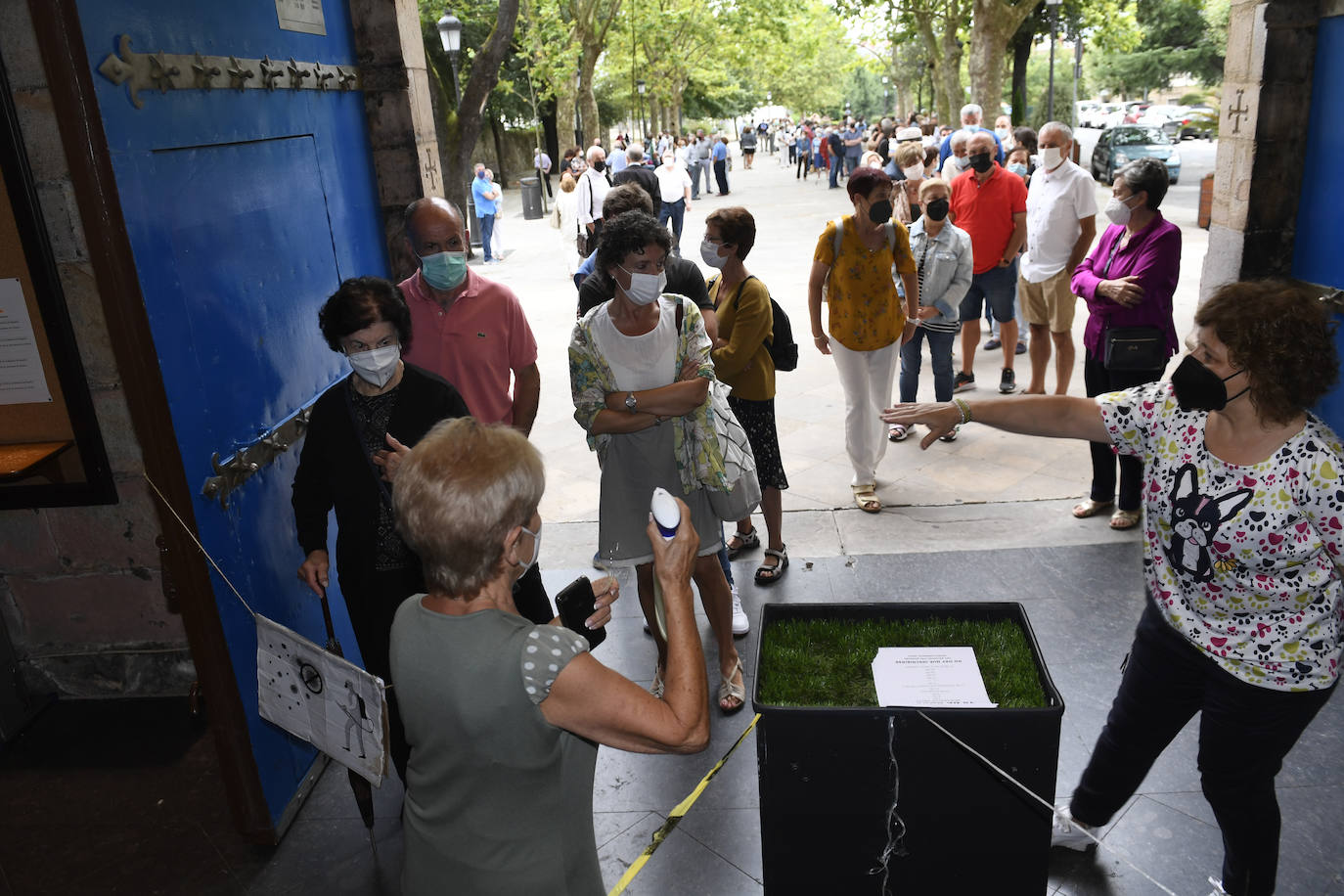 Frente a la basílica se han formado dos largas colas de fieles, muchos de los cuales no han podido acceder al templo por el aforo limitado. 