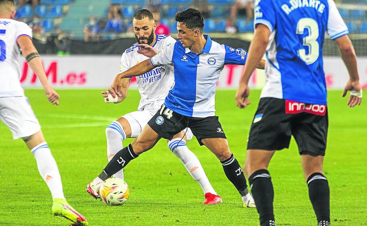 Manu García, siempre en contacto con el balón, lo protege ante el acoso del visitante Benzema. 