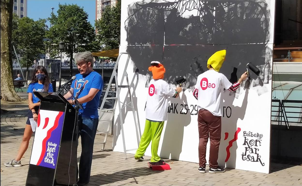 Dos comparseros con el logtotipo de Bilbao borran el cartel de Bilboko Irria. 