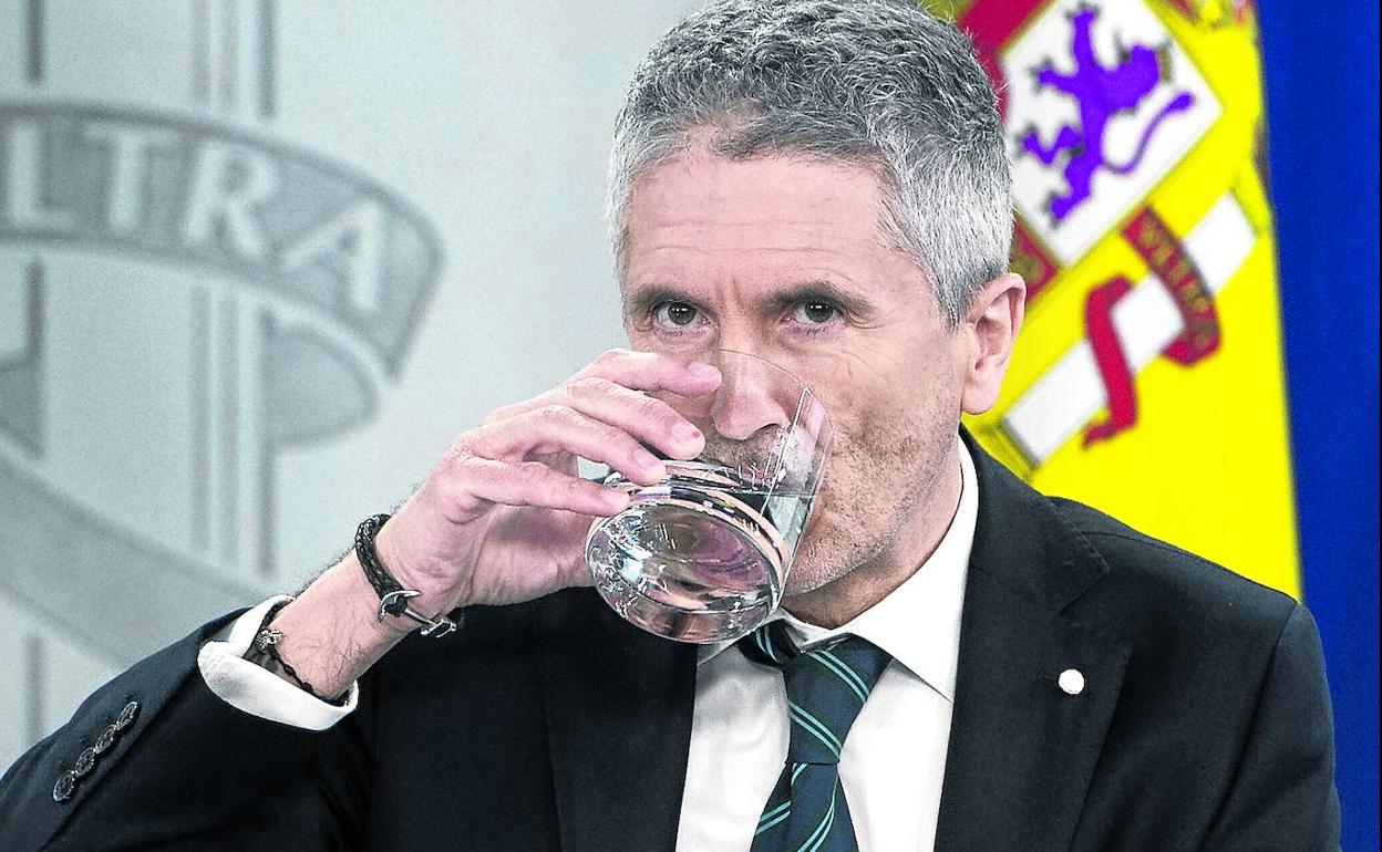 El titular de Interior, Fernando Grande-Marlaska, bebe agua en una rueda de prensa posterior al Consejo de Ministros. 