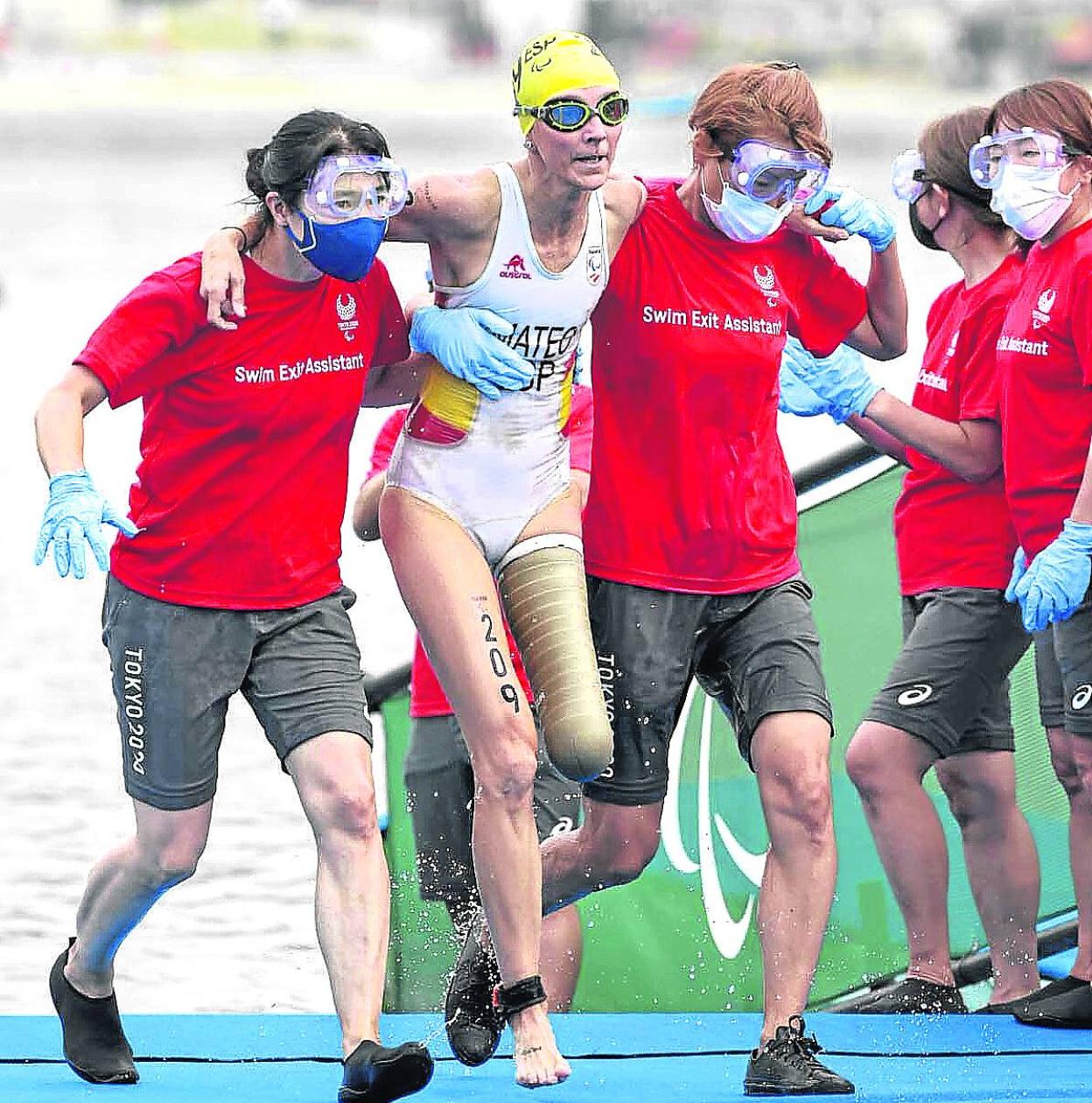 Voluntarios ayudan a Mateo tras la prueba de natación. 