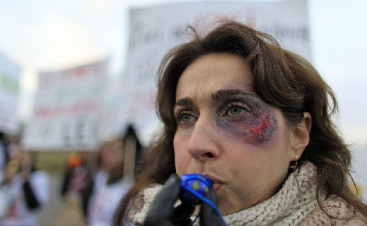 Una mujer maquillada como si hubiera sido agredida, en una manifestación contra la violencia machista. 