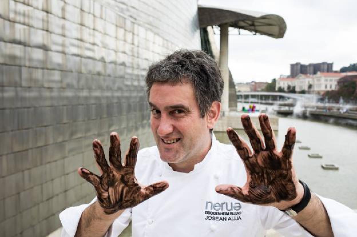 El cocinero Josean Alija posa en el exterior de Nerua en el décimo aniversario de la apertura del restaurante del museo Guggenheim con las manos untadas en salsa de txipirón. 