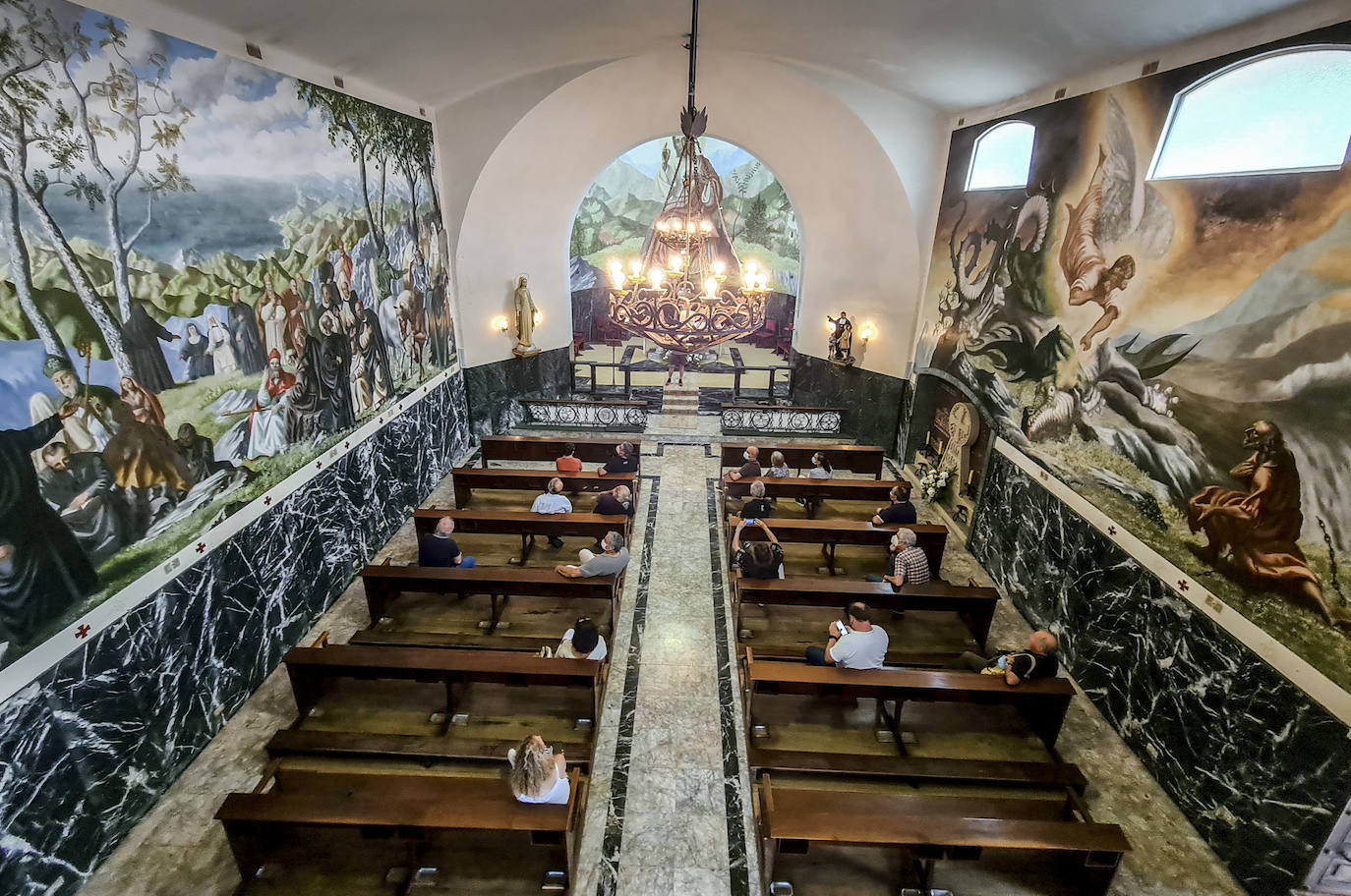 A la derecha, la leyenda de San Miguel Arcángel liberando a Teodosio de Goñi de sus cadenas y a la izquierda, el mural con todos los santos y beatos vascos.