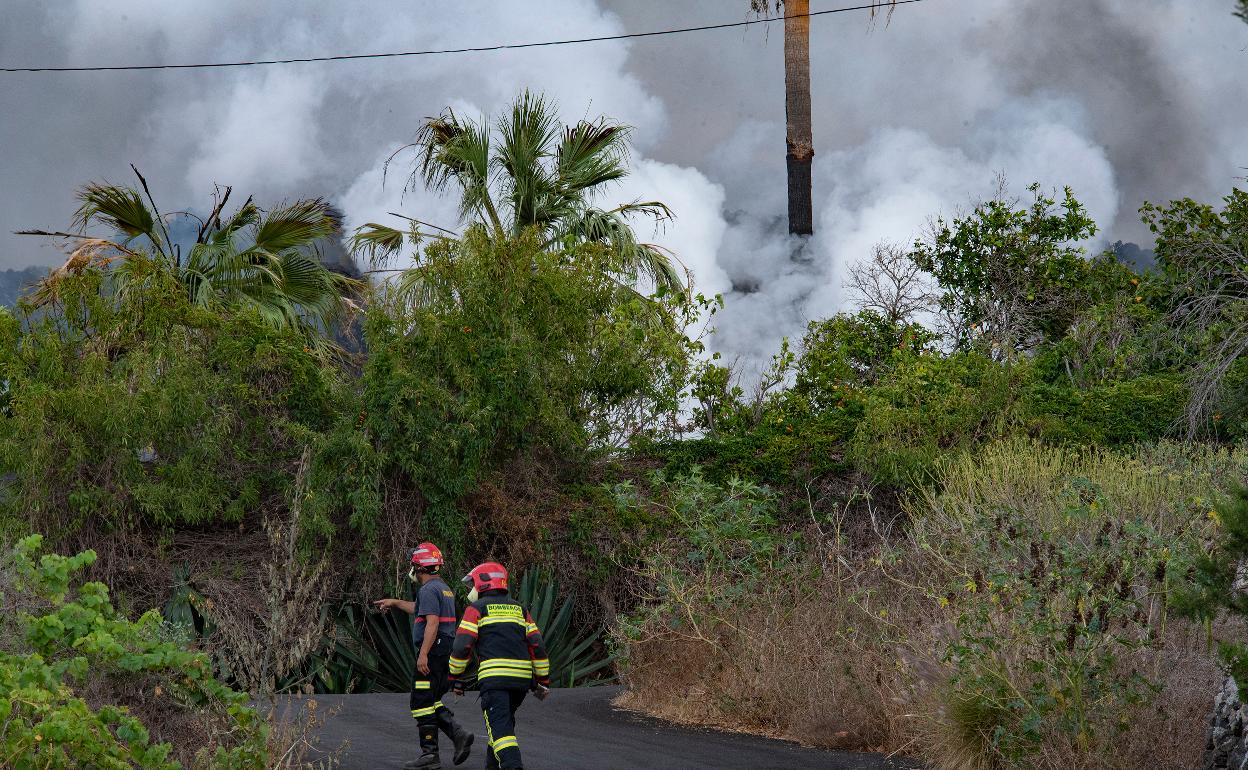 Imagen de los bomberos en una de las zonas devastadas por la lava. 