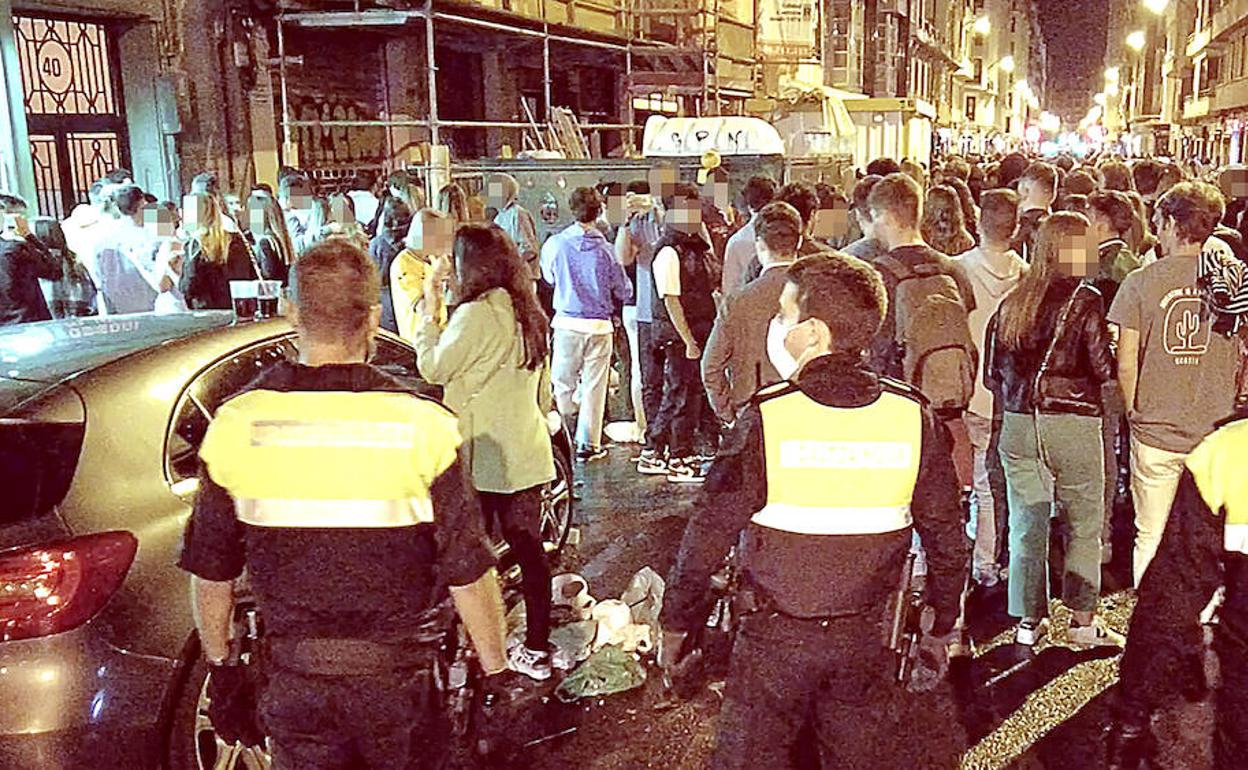 Agentes de la Policía Municipal de Bilbao controlan la aglomeración de jóvenes en la céntrica calle Pozas. 