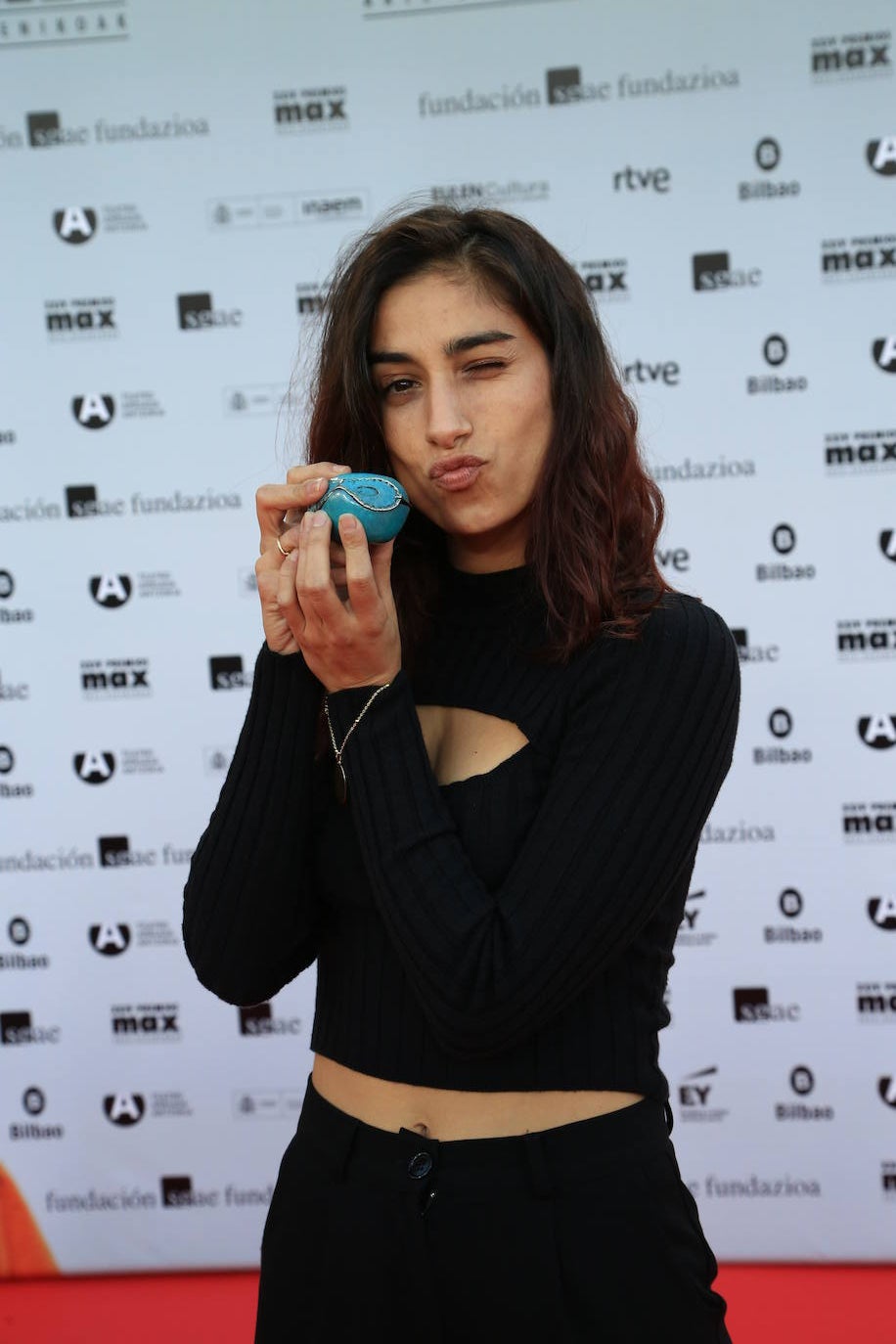 Carolina Yuste, nominada a mejor actriz por Prostitución, eligió un top negro de canalé con escote cut-out en el pecho, pantalones del mismo color y deportivas.