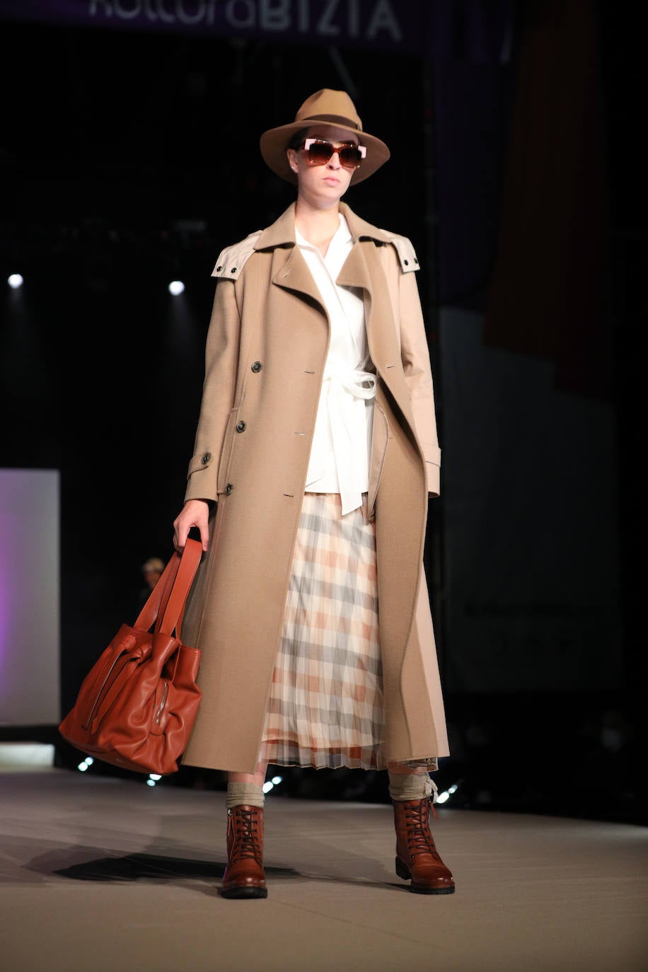 Abrigo de corte masculino, sombrero y botines marrones.