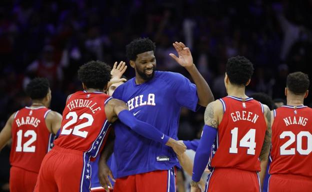 Embiid rodeado por sus compañeros