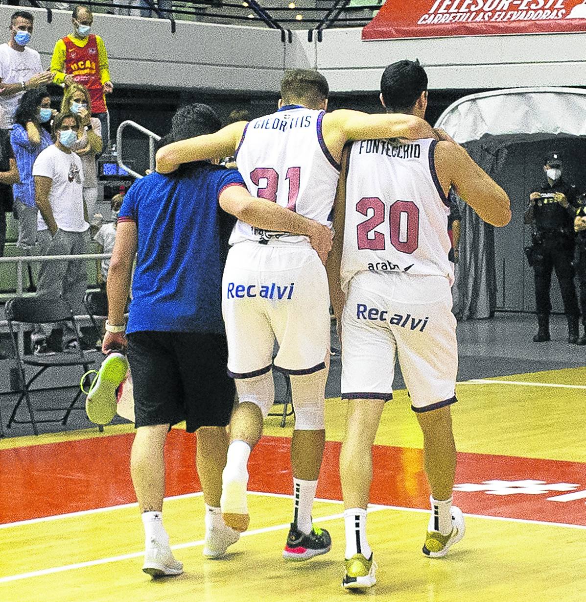 Rokas Giedraitis es ayudado por Fontecchio y un miembro del staff técnico.