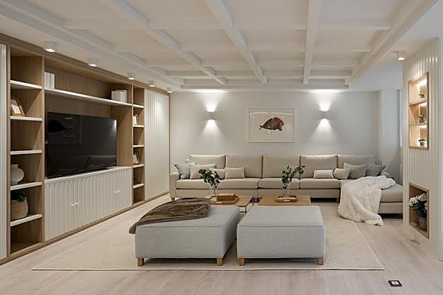 Reforma de una vivienda en Getxo: salón, zona de sofás y librería