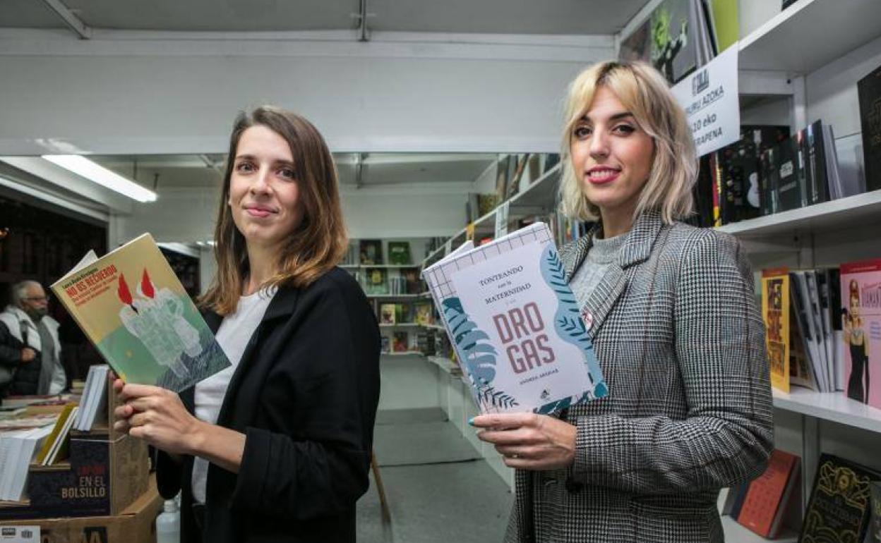 Alzola y Abáigar posan en la caseta de la librería Zuloa junto a sus libros. 