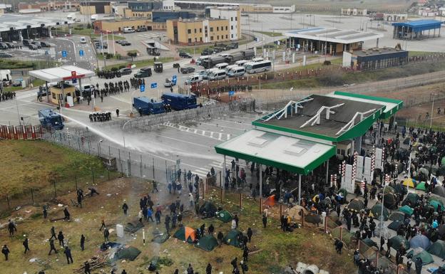 Las fuerzas de seguridad polacas dispersan con cañones de agua a los inmigrantes que les atacan desde territorrio bielorruso, que esperan para saltar las vallas.