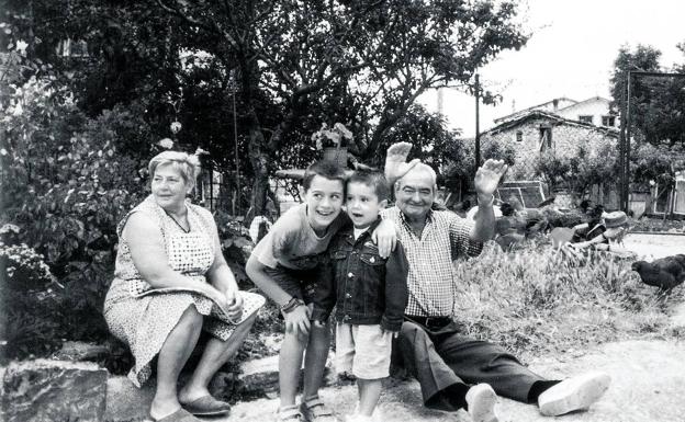 Galería. Josefina Torre y su marido Pablo sentados en la casa del pueblo con dos de sus nietos, Daniel y Jon Zatón.