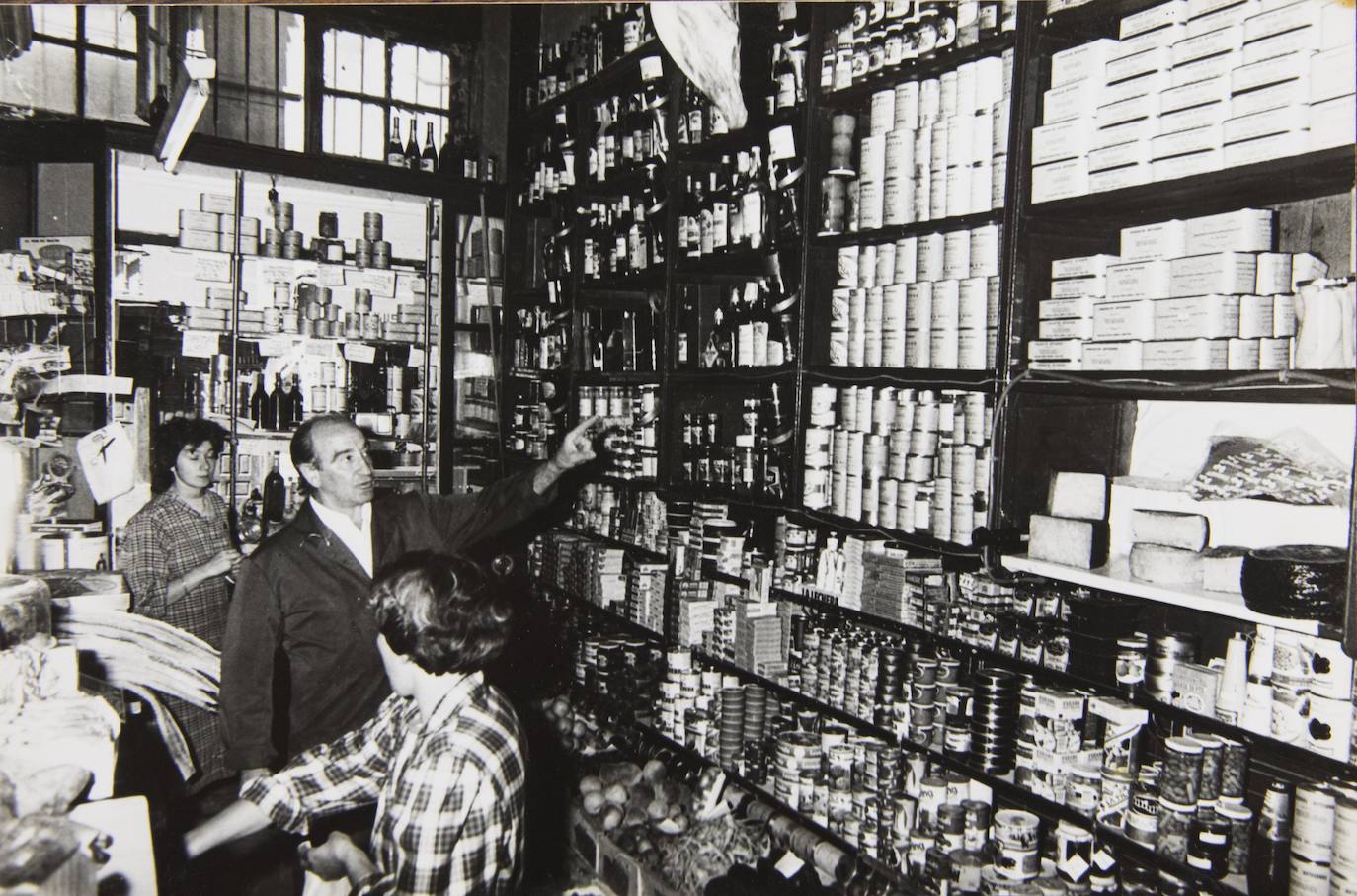 El matrimonio e Isabel, una de las dependientas, entre latas y frascos de conservas.