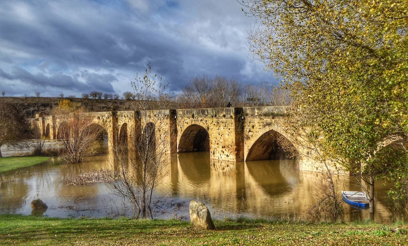 El agua del Ebro cubre los pilares del puente gótico que comunica Briñas con Haro; sobre estas líneas, el caudal supera el muro de contención de la presa de Labastida y, a la derecha, inunda el paseo de Briñas junto al río. 