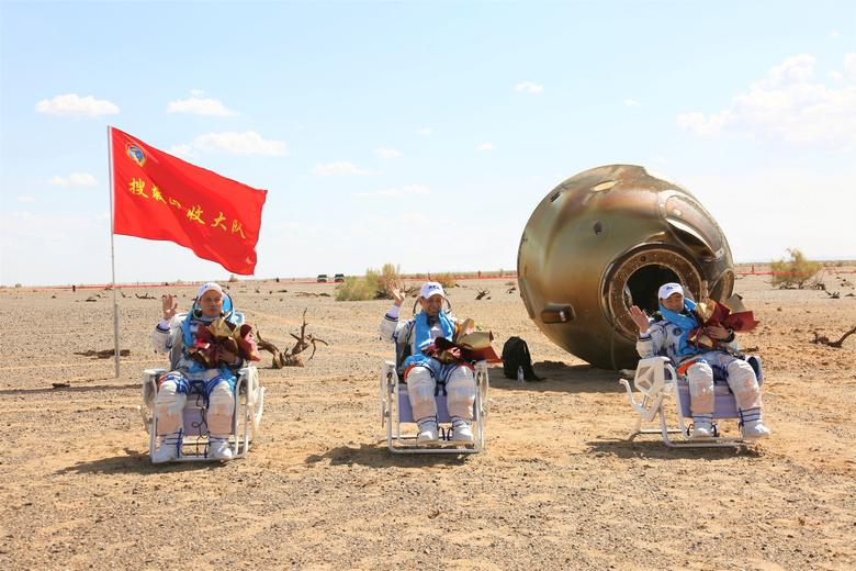 Los astronautas chinos Nie Haisheng (C), Liu Boming (R) y Tang Hongbo saludan frente a su cápsula de regreso después de su regreso a la tierra luego de la misión Shenzhou-12 para ensamblar la estación espacial de China en la Región Autónoma de Mongolia Interior, China, el 17 de septiembre.