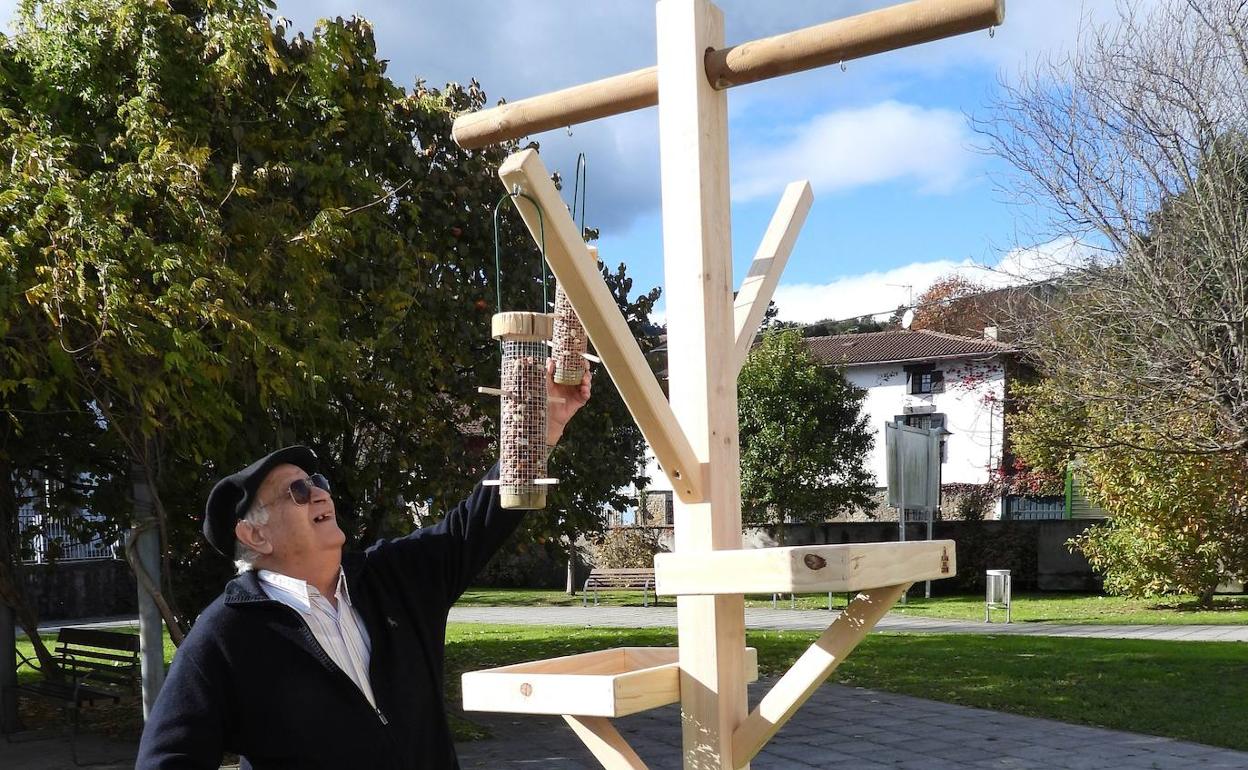 Un residente llena de género uno de los comederos destinados a los pájaros silvestres en el centro Arrotegi de Busturia.