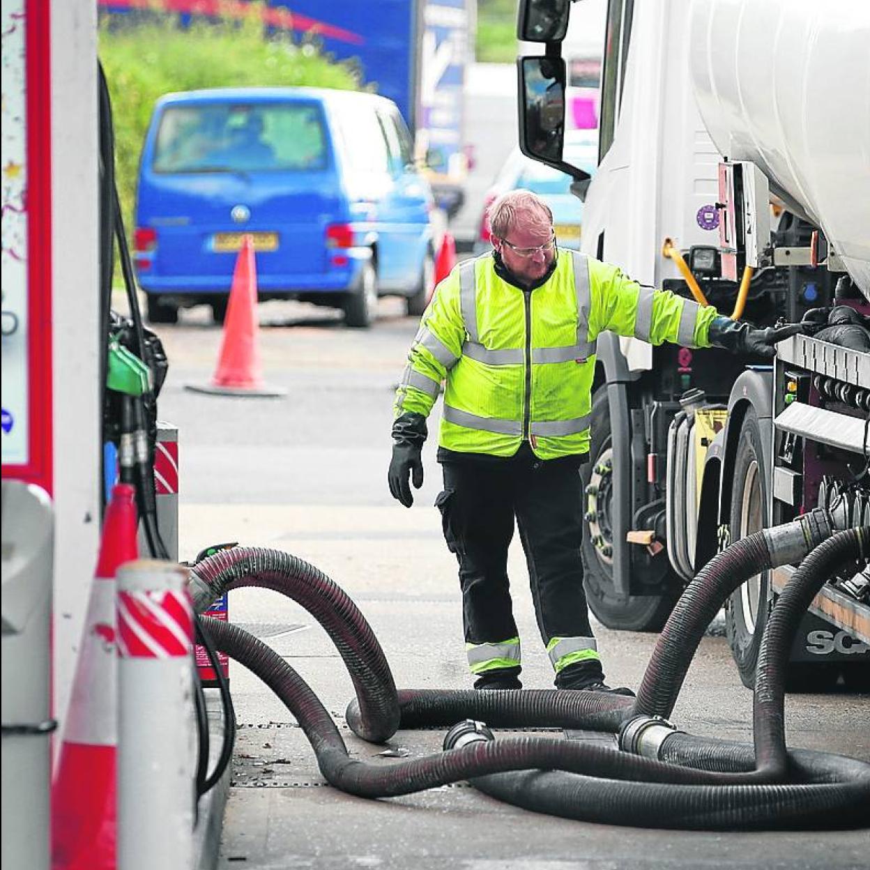 Un camión cisterna descarga combustible en una gasolinera. 