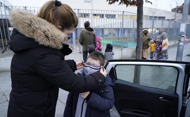 Maite García le ajusta la mascarilla a su hijo.